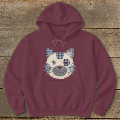 Burgundy hoodie with a patchwork cat face design on the chest.
