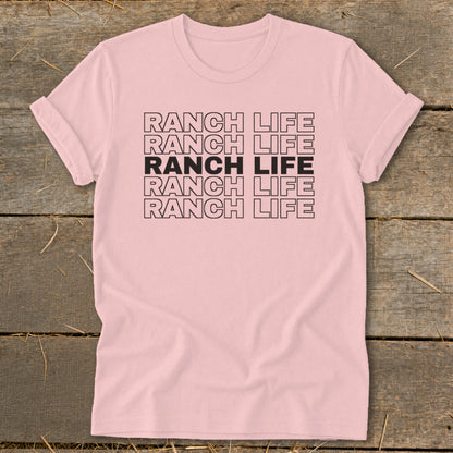 A light pink t-shirt with rolled sleeves features the text RANCH LIFE repeated in five stacked rows.