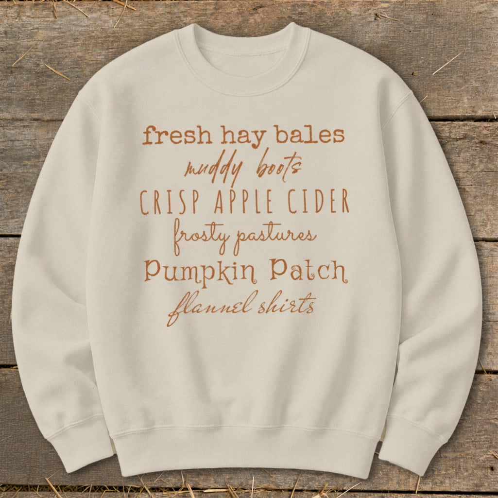 Cream sweatshirt with "fresh hay bales, muddy boots, crisp apple cider, frosty pastures, pumpkin patch, flannel shirts" text.