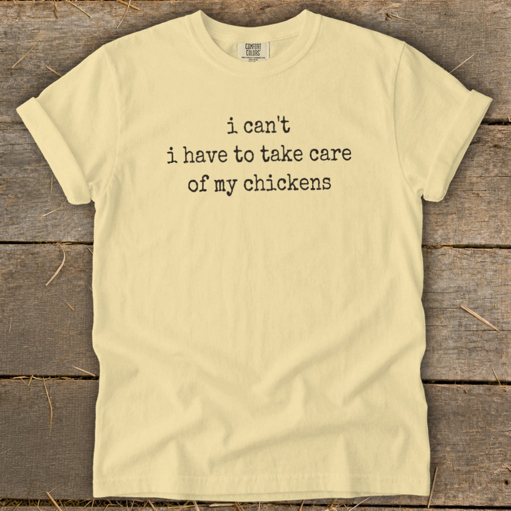 Light yellow t-shirt with black text that reads "i can't i have to take care of my chickens".