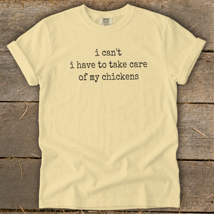 Light yellow t-shirt with black text that reads "i can't i have to take care of my chickens".