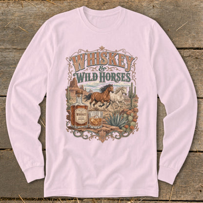 Whiskey & Wild Horses graphic on a light pink long-sleeve shirt featuring horses, whiskey bottle and glass.