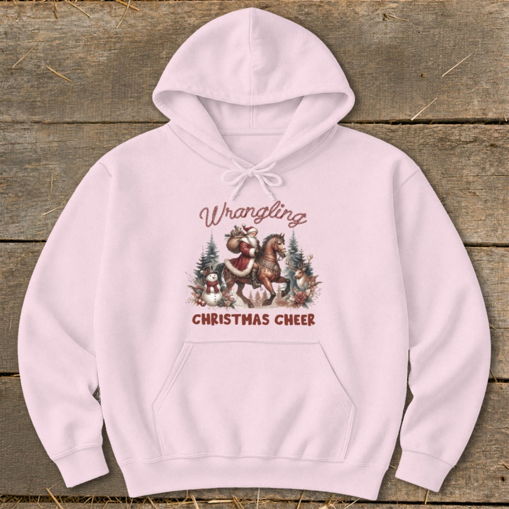Pink hoodie with "Wrangling Christmas Cheer" and Santa on a horse graphic.