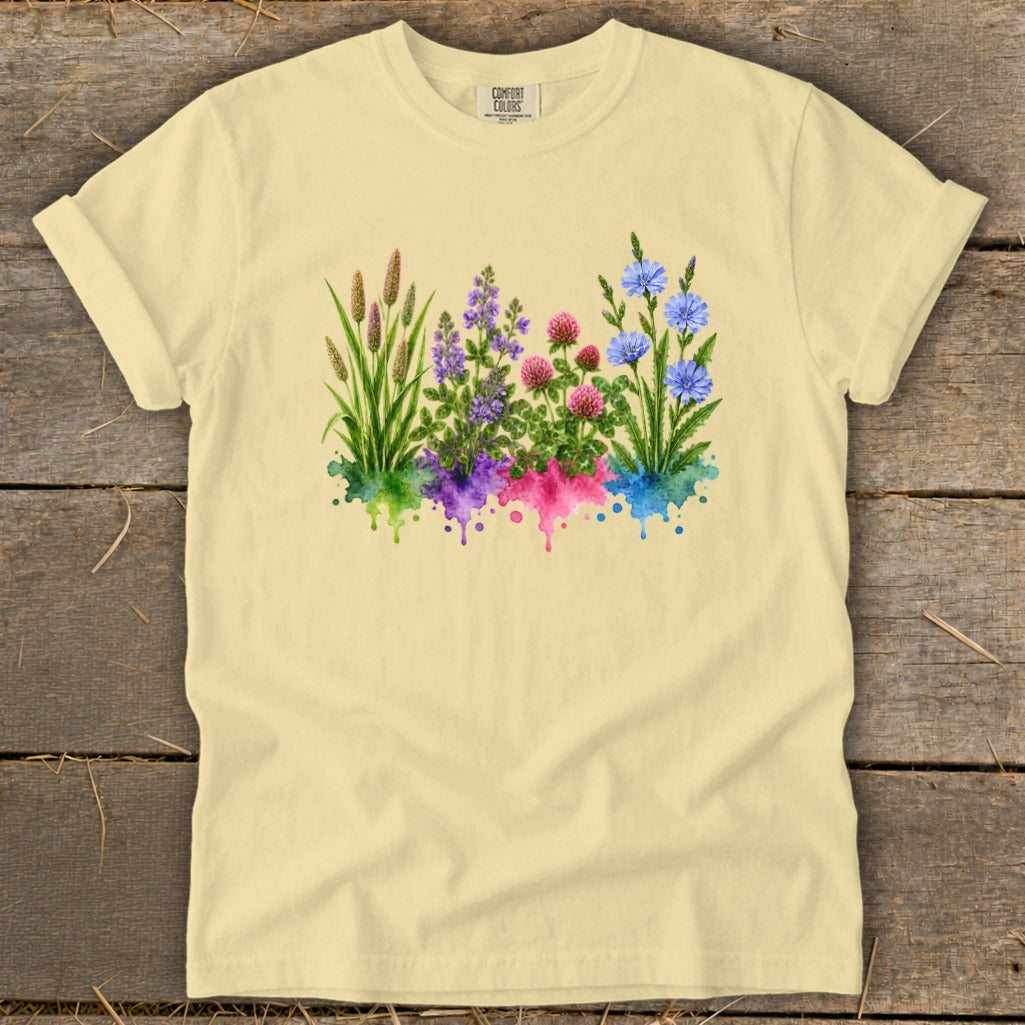 A light yellow short-sleeve t-shirt features a colorful botanical watercolor illustration of wildflowers centered on the chest.