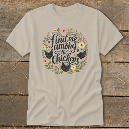 Light tan t-shirt with floral wreath and "Find me among the chickens" text.