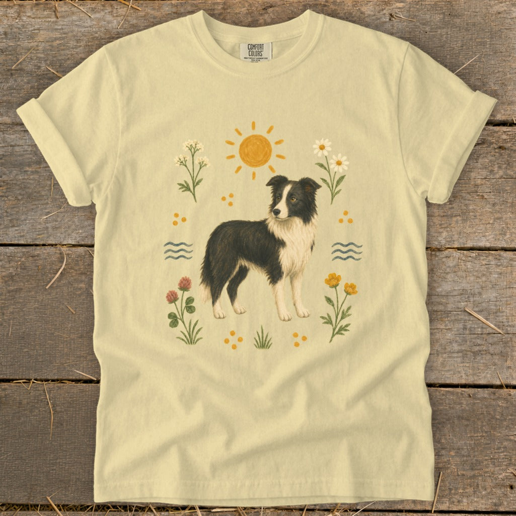 Light yellow t-shirt with a border collie dog surrounded by flowers and a sun.