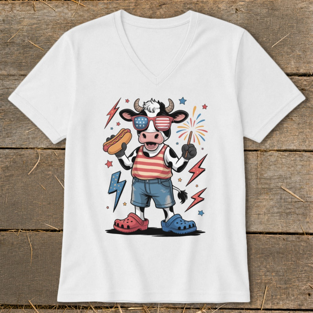 Cow in patriotic sunglasses holding hot dog and sparkler with fireworks.