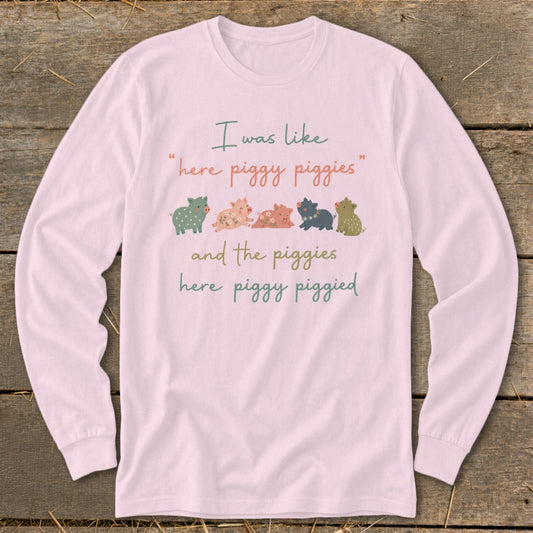 Long sleeve pink shirt with a graphic of five cartoon pigs and text.