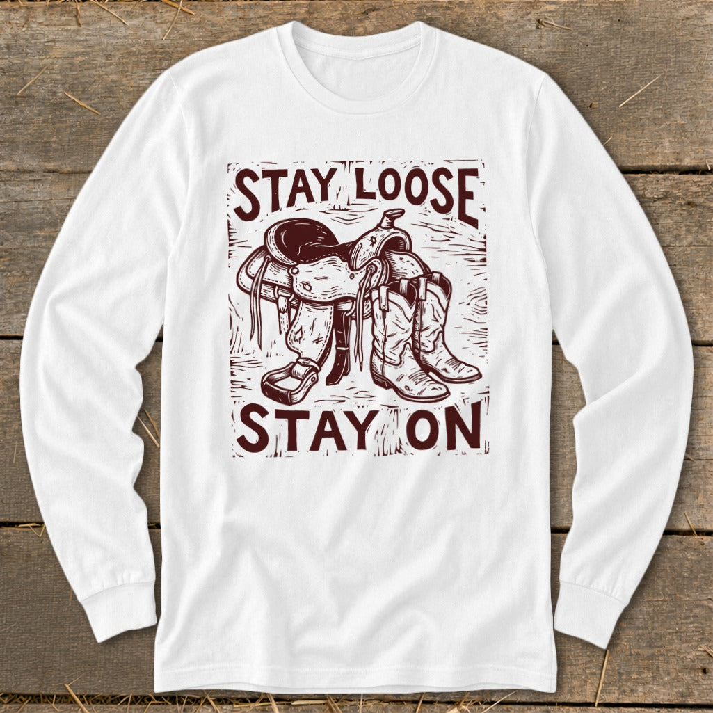 White long sleeve shirt with "STAY LOOSE STAY ON" text and saddle and boots graphic.