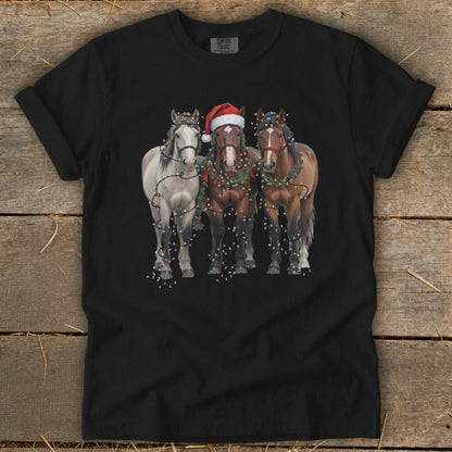 Black t-shirt with three horses decorated in Christmas lights and garland.