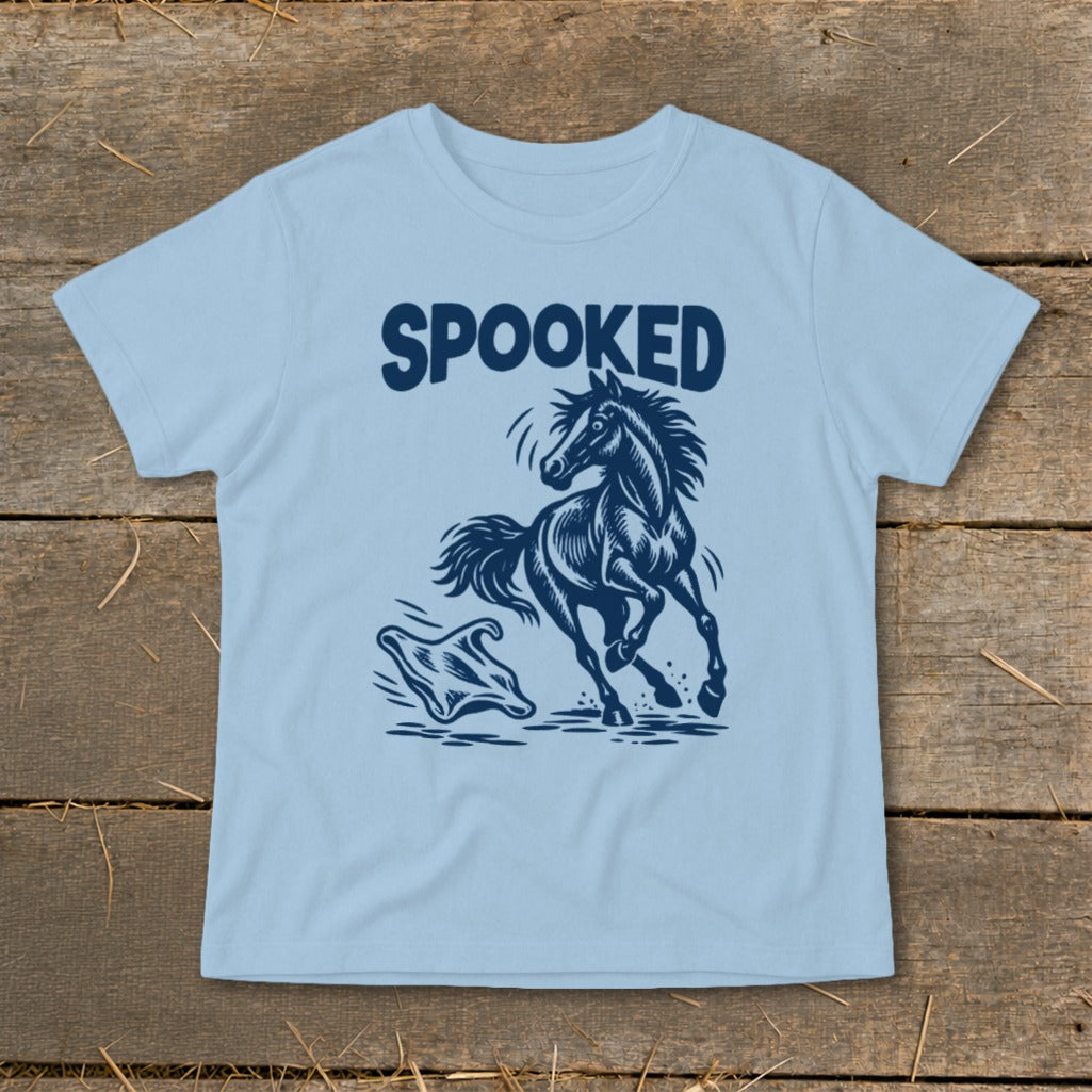 Light blue t-shirt with navy graphic of a running horse and a ghost, with "SPOOKED" text.