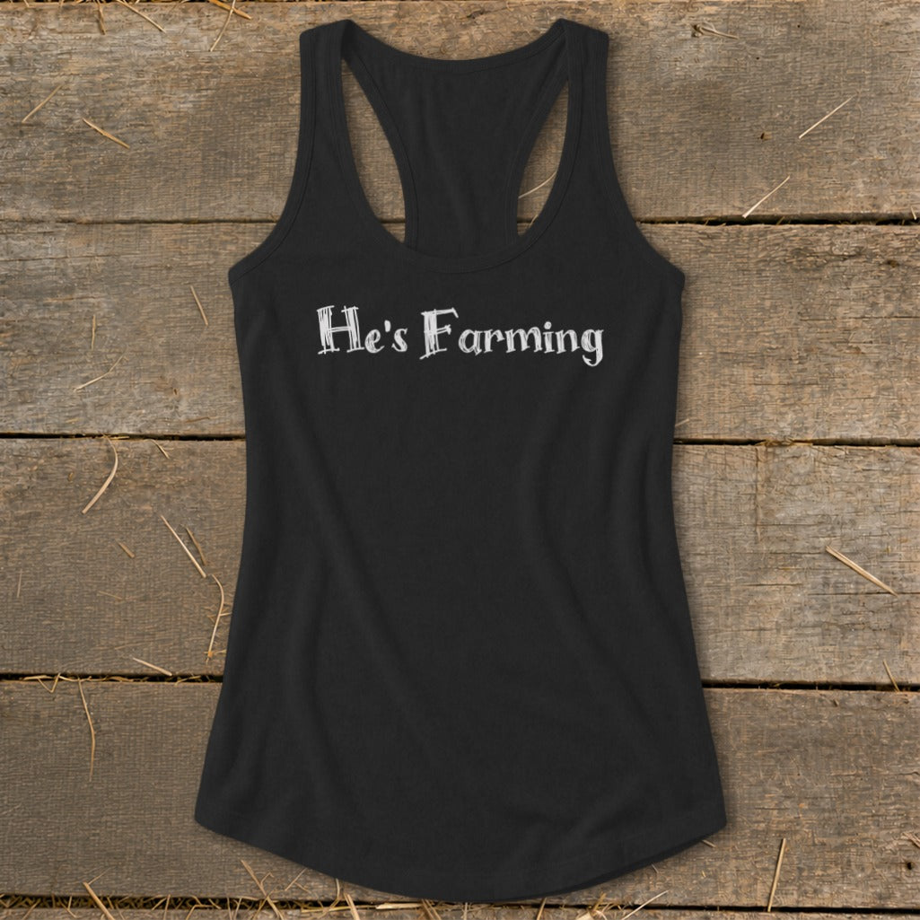 Black racerback tank top with white text "He's Farming"