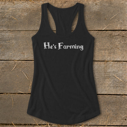 Black racerback tank top with white text "He's Farming"