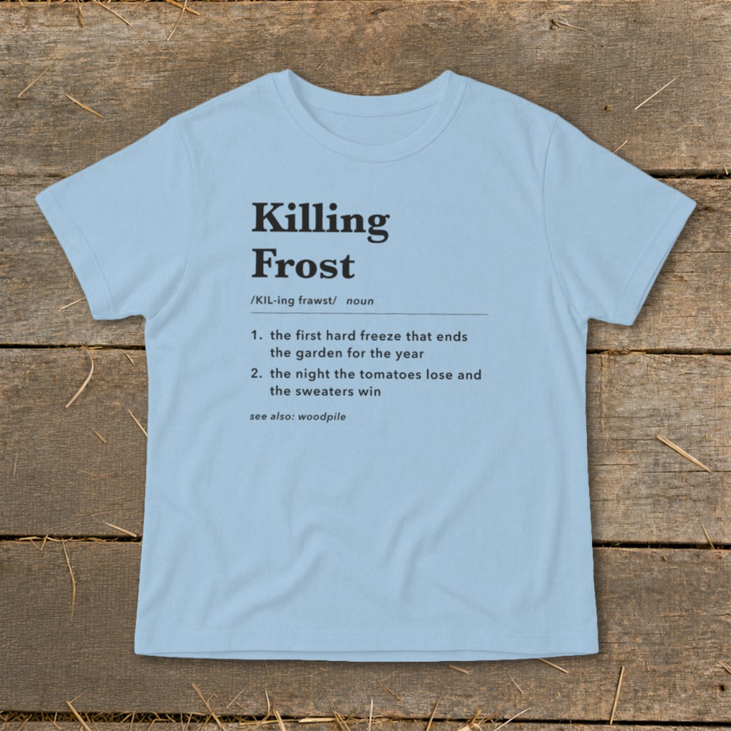 Light blue t-shirt featuring dictionary-style text defining Killing Frost laid flat on wooden planks.