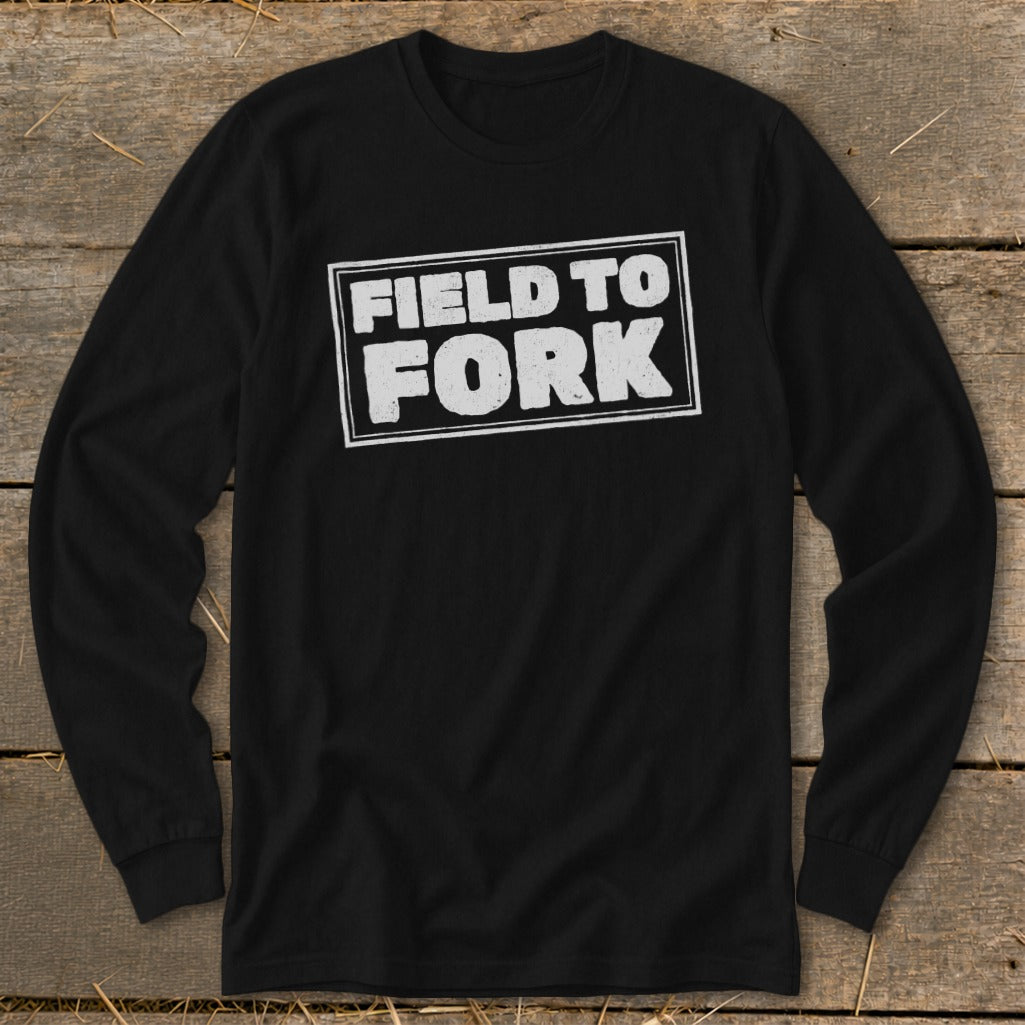 A black long-sleeve t-shirt with a white rectangular border enclosing the text "FIELD TO FORK" on the chest.