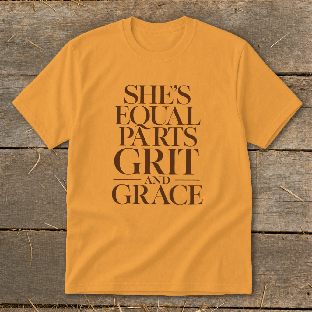 Yellow t-shirt with brown text reading "SHE'S EQUAL PARTS GRIT AND GRACE".
