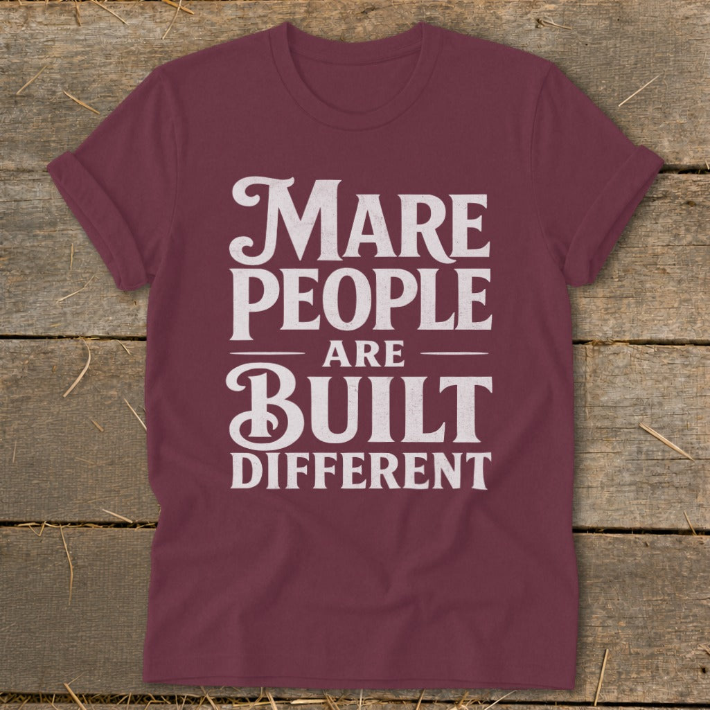 Maré People are built different t-shirt with white text on maroon.