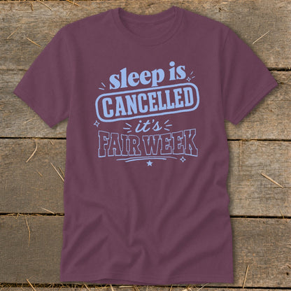 Maroon t-shirt with light blue text that reads "sleep is CANCELLED it's FAIR WEEK".