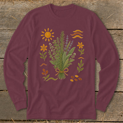 Maroon long-sleeve shirt with a central bouquet of herbs surrounded by botanical elements and a sun.