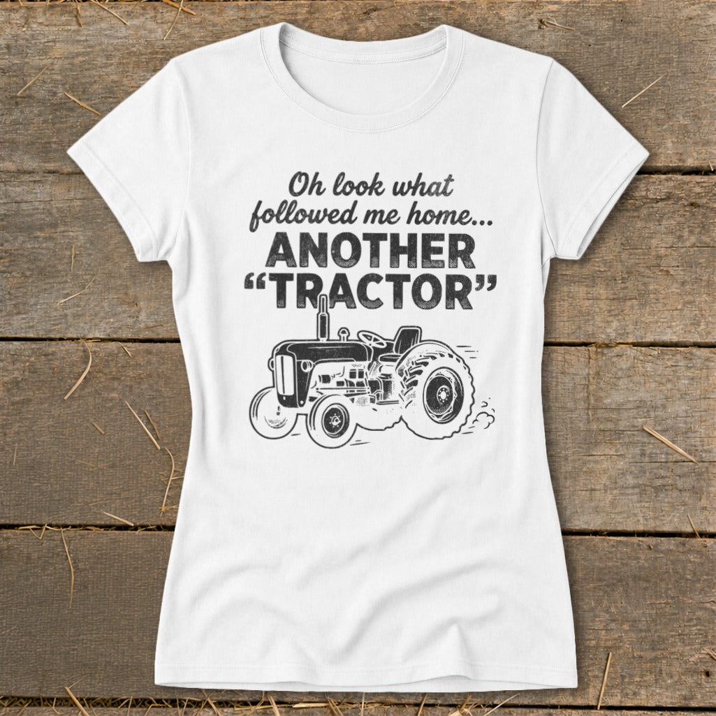 White t-shirt with "Oh look what followed me home... ANOTHER 'TRACTOR'" and tractor graphic.