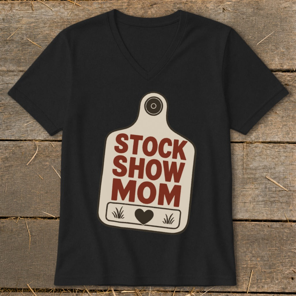 Black v-neck t-shirt with "STOCK SHOW MOM" text on a cow tag graphic.