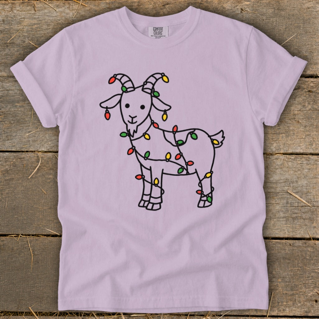 Light purple t-shirt with a drawing of a goat wrapped in colorful Christmas lights.