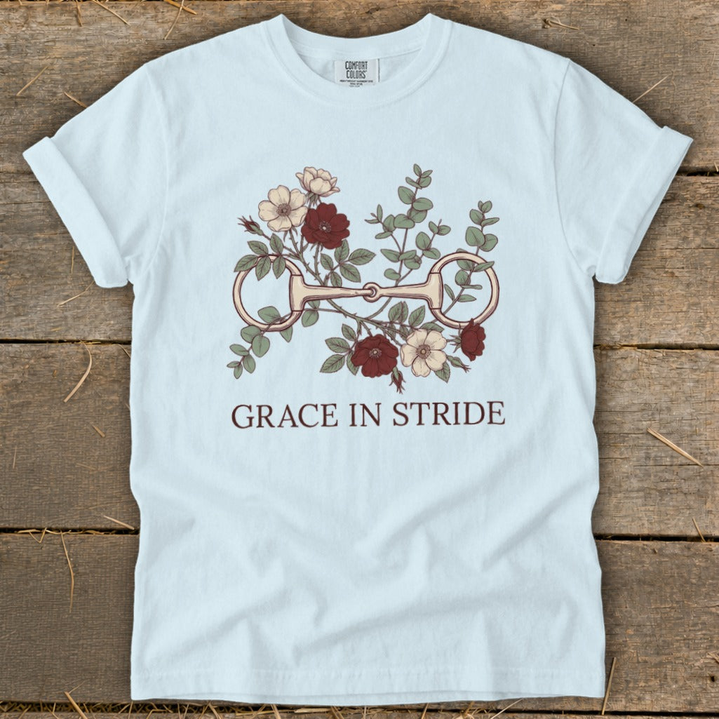 Light blue t-shirt with floral design and horse bit, reads "GRACE IN STRIDE".