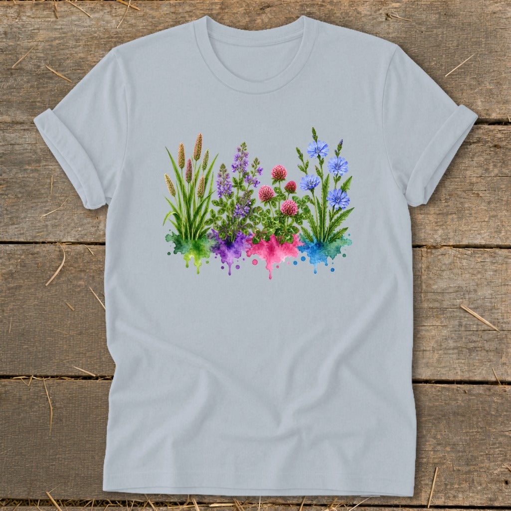 A light gray t-shirt featuring a watercolor graphic of colorful wildflowers and grasses on a wooden surface.