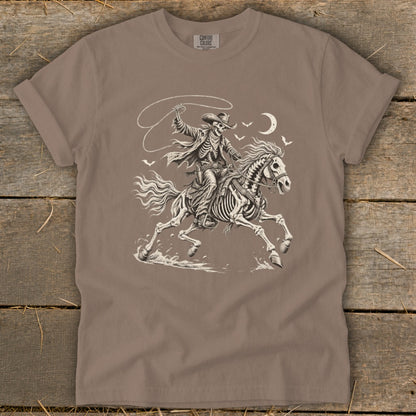 Skeleton cowboy on horseback with lasso, crescent moon and birds, Comfort Colors shirt.