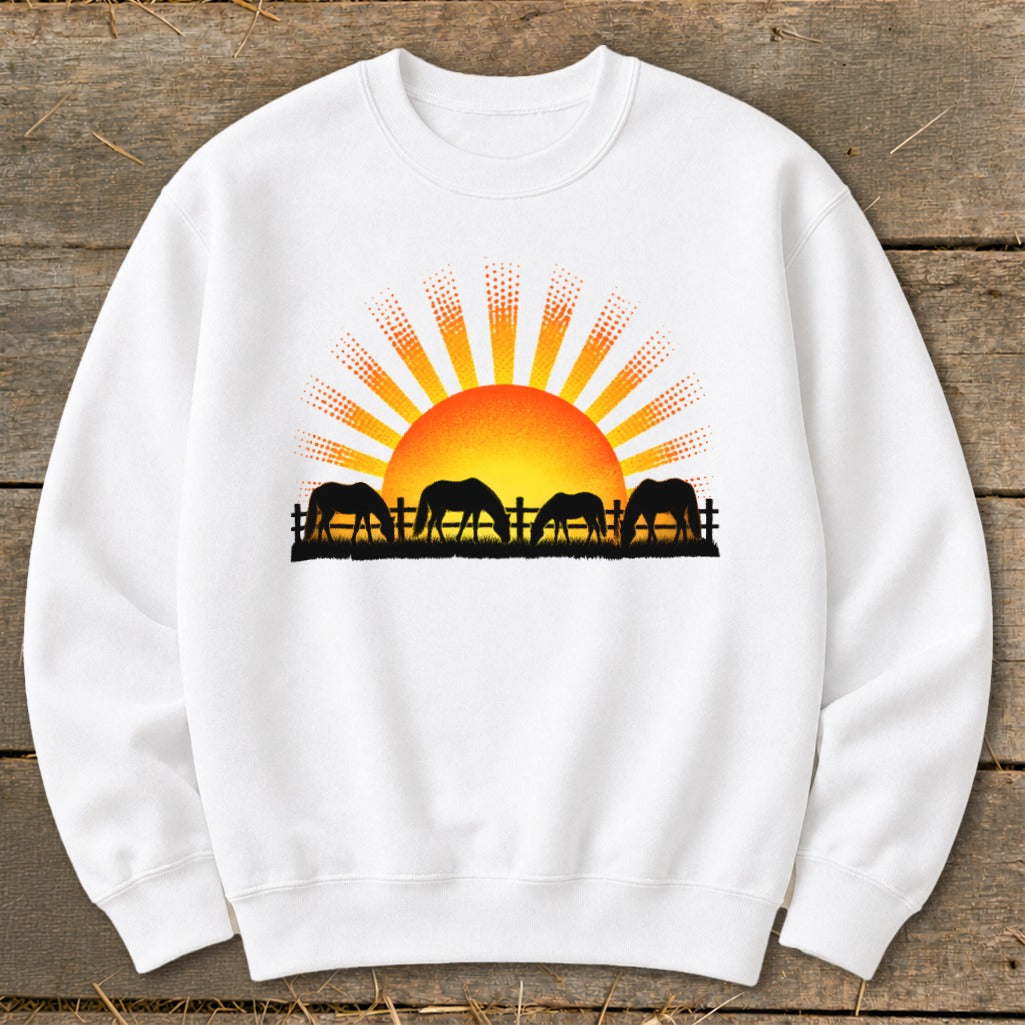 White sweatshirt with black horse silhouettes grazing in front of a rising sun.