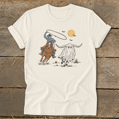 Skeleton cowboy on a horse chasing a longhorn ghost with bats and moon.