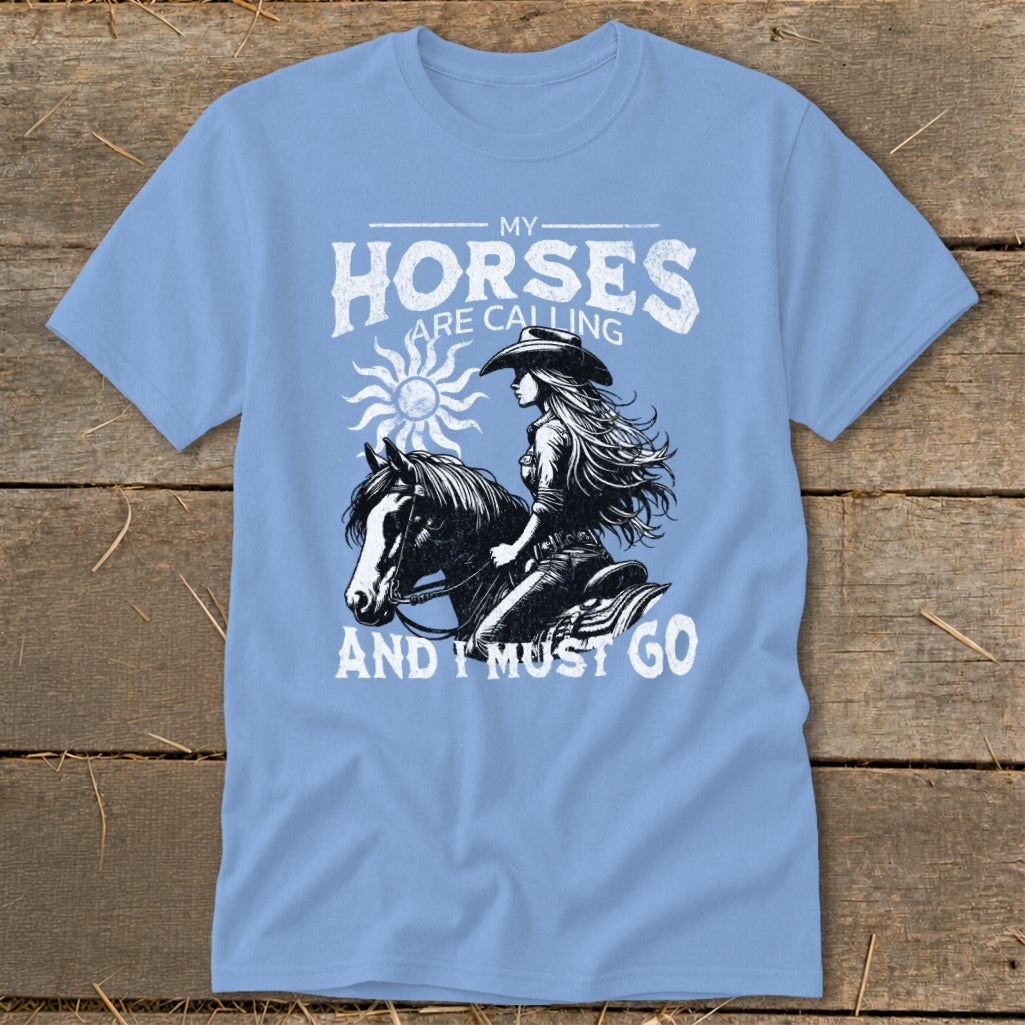 Light blue t-shirt with graphic of woman riding a horse and text "My Horses Are Calling And I Must Go".