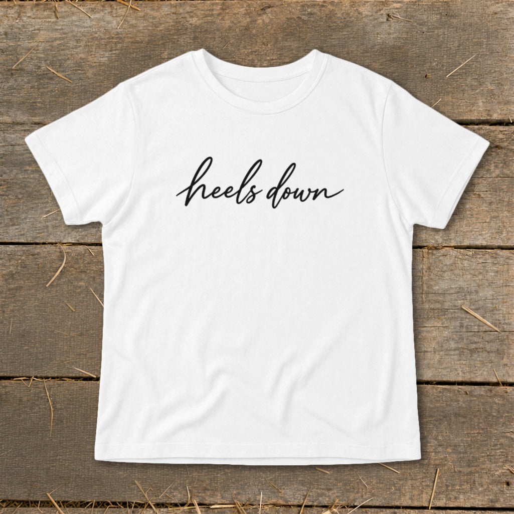 White t-shirt with black cursive text that reads "heels down".