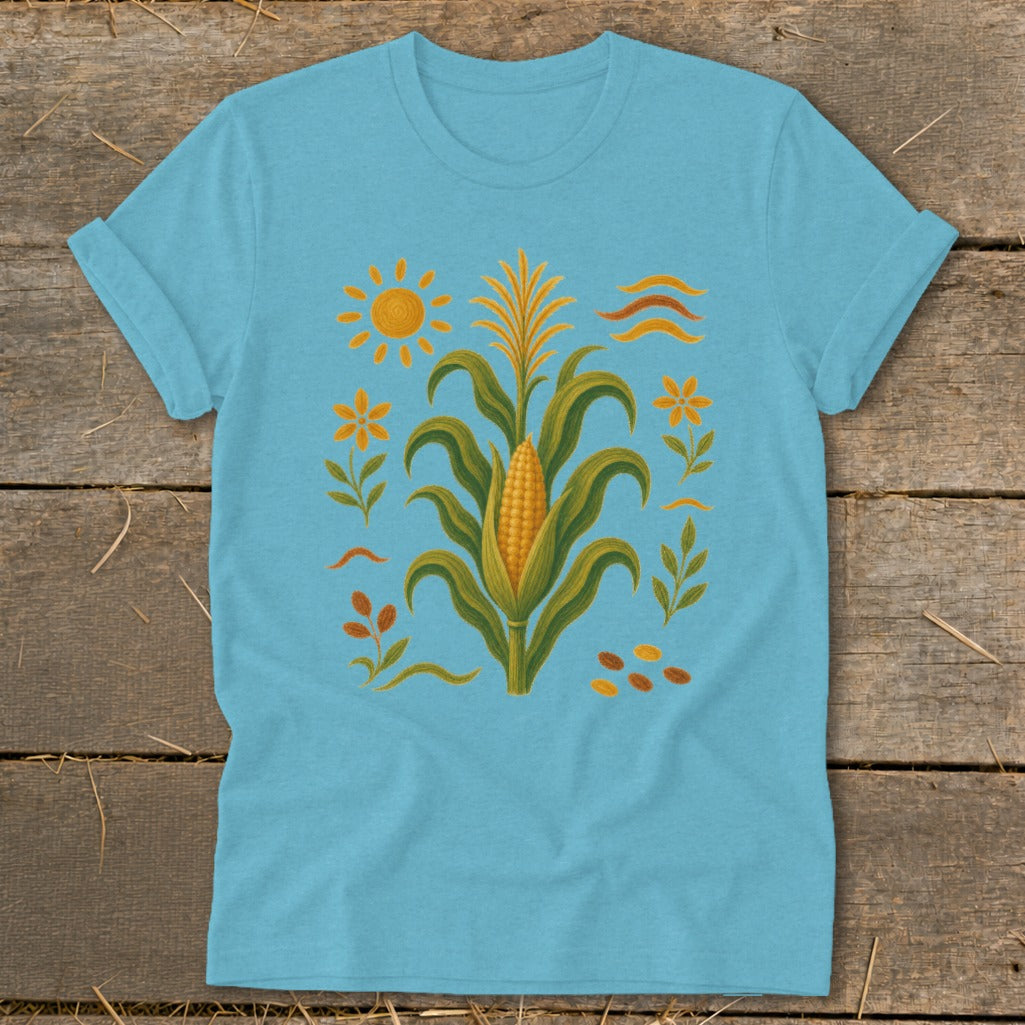 Light blue t-shirt with corn stalk, sun, flowers, and wavy lines design.