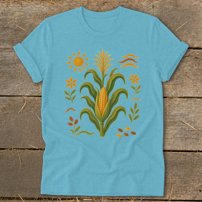 Light blue t-shirt with corn stalk, sun, flowers, and wavy lines design.