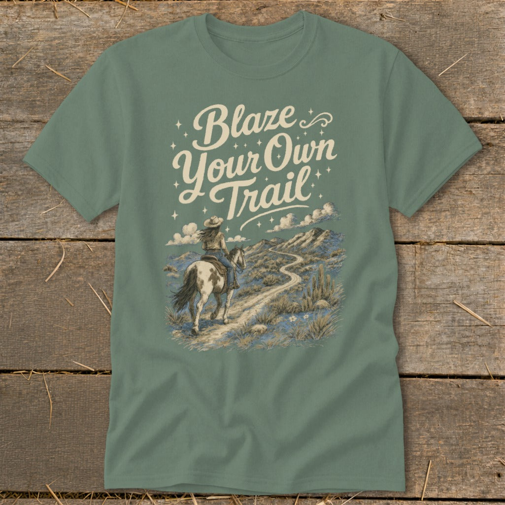 T-shirt with text "Blaze Your Own Trail" and desert landscape with person riding a horse.