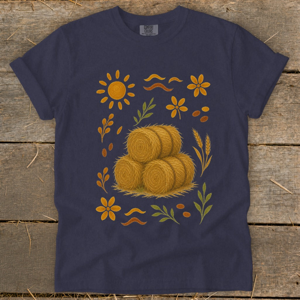 Navy t-shirt with stacked hay bales and autumn floral design.