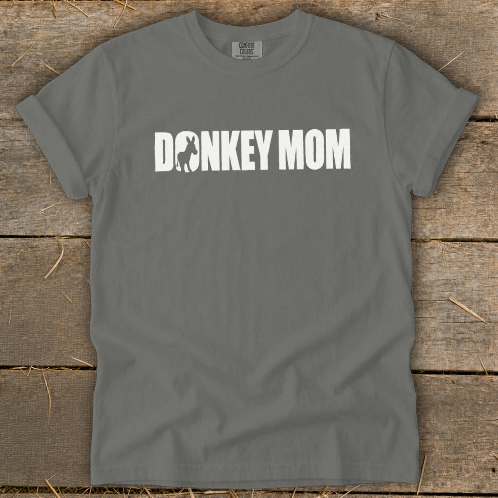 A grey crewneck t-shirt with rolled sleeves features white text reading DONKEY MOM, with a donkey silhouette inside the letter O.