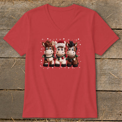 Three cartoon horses in festive attire with snowflakes on a red t-shirt.