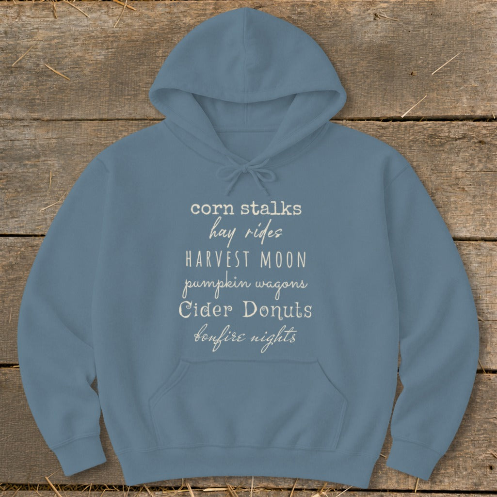 Blue hoodie with fall-themed text: "corn stalks, hay rides, harvest moon, pumpkin wagons, cider donuts, bonfire nights".