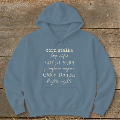 Blue hoodie with fall-themed text: "corn stalks, hay rides, harvest moon, pumpkin wagons, cider donuts, bonfire nights".