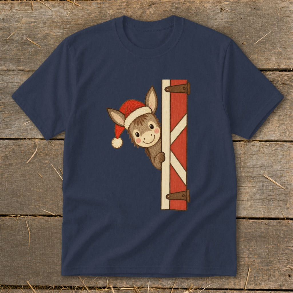 Donkey wearing Santa hat peeking from behind a barn door.