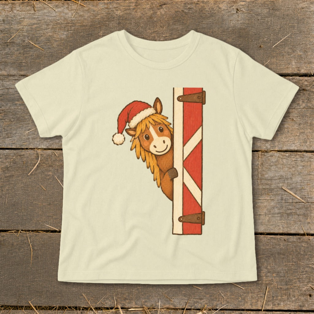 Horse wearing Santa hat peeking from behind a red barn door.