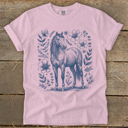 Pink t-shirt with navy blue sketch of a horse surrounded by flowers.