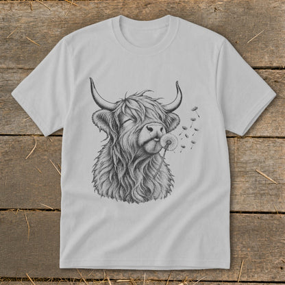 Grey t-shirt with a black ink drawing of a Highland cow blowing a dandelion.