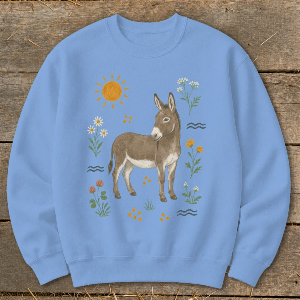 Light blue sweatshirt with a watercolor illustration of a donkey surrounded by flowers and a sun.