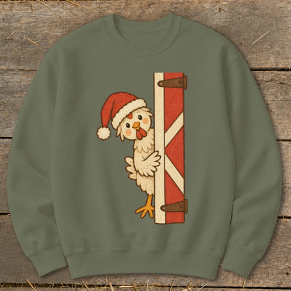 Chicken in Santa hat peeking from behind a red barn door.