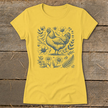Yellow t-shirt with blue line art of a chicken surrounded by flowers and foliage.