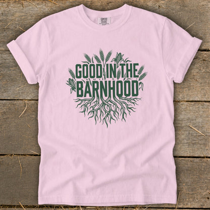 Pink t-shirt with green text and graphics reading "GOOD IN THE BARNHOOD".