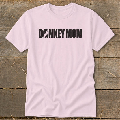 A light pink t-shirt featuring the black text DONKEY MOM with a donkey silhouette replacing the letter O.